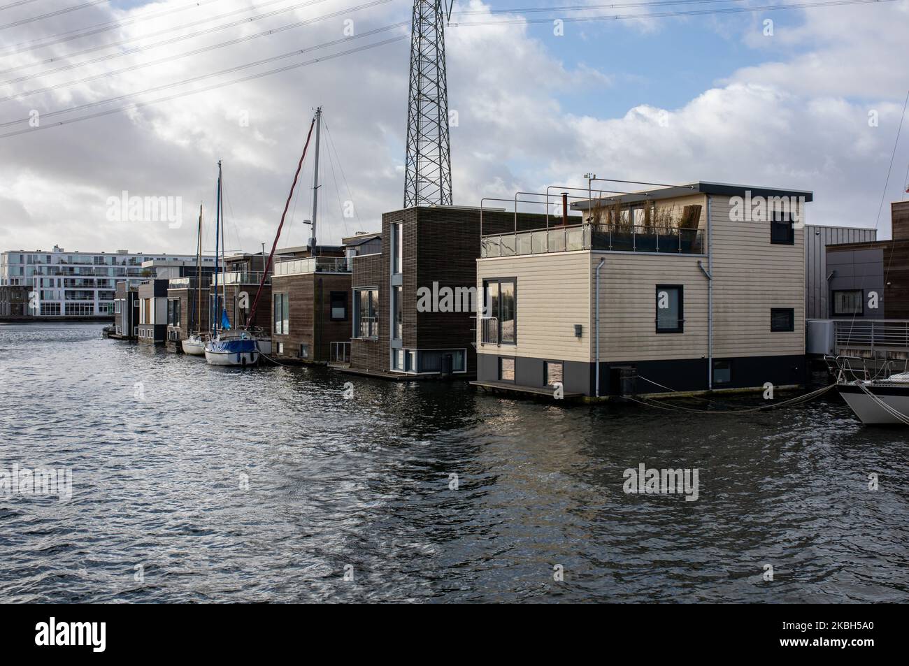 Case galleggianti ad Amsterdam visto il 17 febbraio 2020. I Paesi Bassi sono un paese protetto dalle dighe, dove le persone vivono su tumuli di origine umana che li innalzano sopra il livello del mare, e nell'acqua su case galleggianti. Le case galleggianti e gli hotel galleggianti possono essere visti lungo i canali di Amsterdam e di altre città. Le case galleggianti sono state suggerite come una soluzione vitale, ecofriendly e sostenibile alle necessità di alloggiamento dell'Olanda moderna. Un esempio di case galleggianti ad Amsterdam è lo Steigereiland, la prima isola costruita parte dell'arcipelago di IJburg, nella parte orientale della città. Quest'isola wa Foto Stock