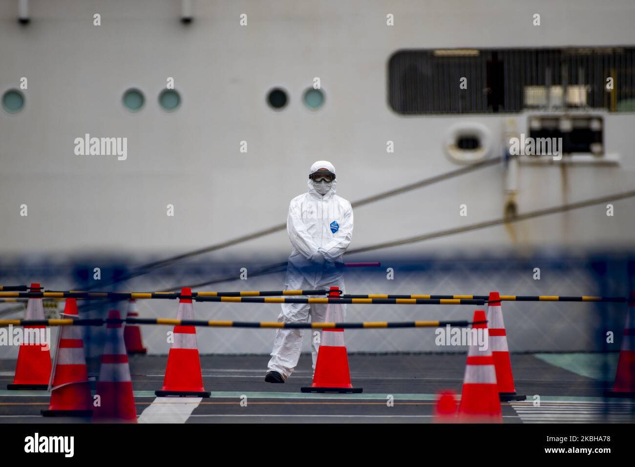 I lavoratori in equipaggiamento protettivo aspettano per scortare i passeggeri che sbarcano dalla nave da crociera Diamond Princess ormeggiata al Porto di Yokohama, a sud di Tokyo, Giappone, il 20 febbraio 2020. (Foto di Alessandro di Ciommo/NurPhoto) Foto Stock