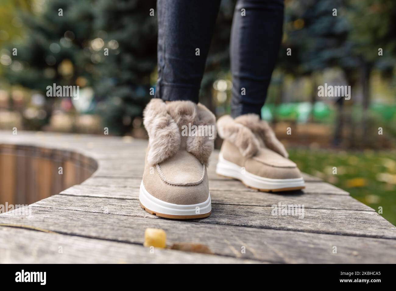 Eleganti scarpe beige autunno-inverno con pelliccia leggera e strass sulle  pietre di pavimentazione grigie Foto stock - Alamy