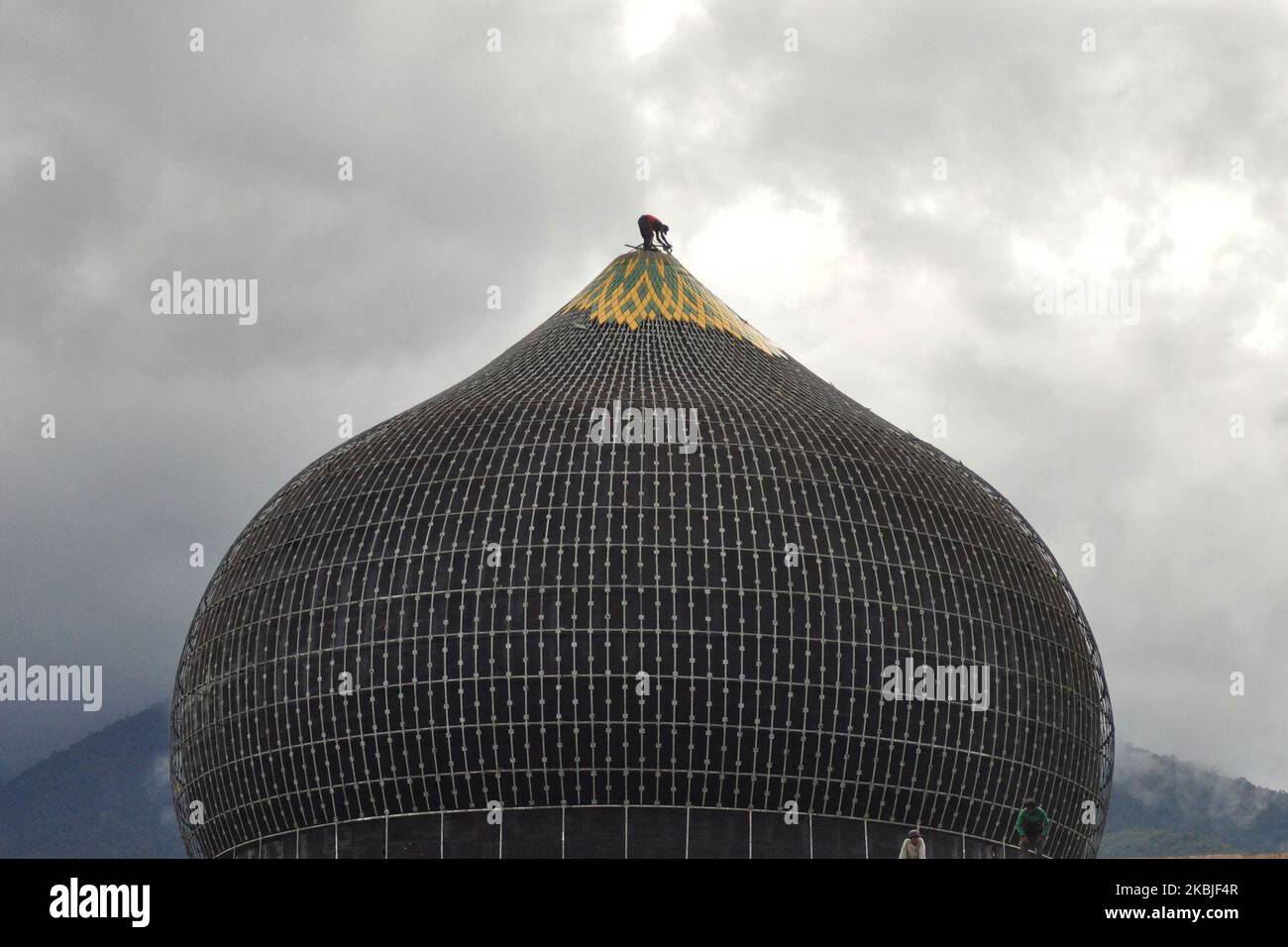 Un lavoratore è in piedi in cima alla cupola della Grande Moschea di Darussalam Palu senza usare la sicurezza, Sulawesi centrale, Indonesia, per fare riparazioni il giovedì 5 marzo 2020. I lavoratori livelleranno la moschea entro il tempo stabilito dal governo della Provincia Centrale di Sulawesi, Indonesia, per poi ricostruirsi attraverso il processo di concorso dopo essere stati gravemente danneggiati dal disastro naturale di un terremoto di grandezza 8,4 nel settembre 2018 fa. (Foto di Faldi Muhammad/NurPhoto) Foto Stock