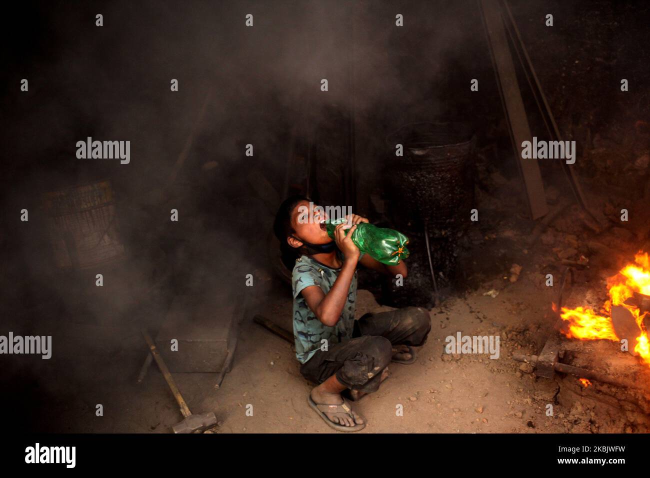 Mehedi(10), beve acqua durante il lavoro in un cantiere navale vicino al fiume Buriganga a Dhaka, Bangladesh il Mercoledì, 11 marzo 2020. Lavora più di 12 ore al giorno per guadagnare 12 dollari alla settimana. Il luogo di lavoro è estremamente caldo e molto pericoloso, non adatto per i bambini. (Foto di Syed Mahamudur Rahman/NurPhoto) Foto Stock