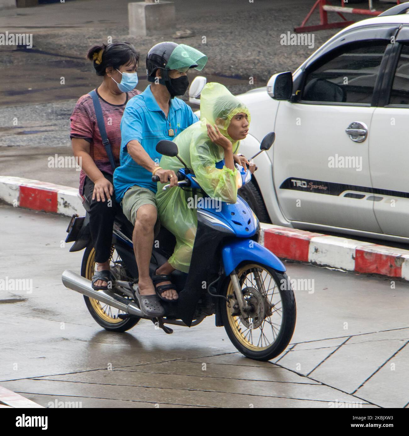 SAMUT PRAKAN, THAILANDIA, ottobre 11 2022, Un popolo in un impermeabile è in moto su una strada bagnata Foto Stock