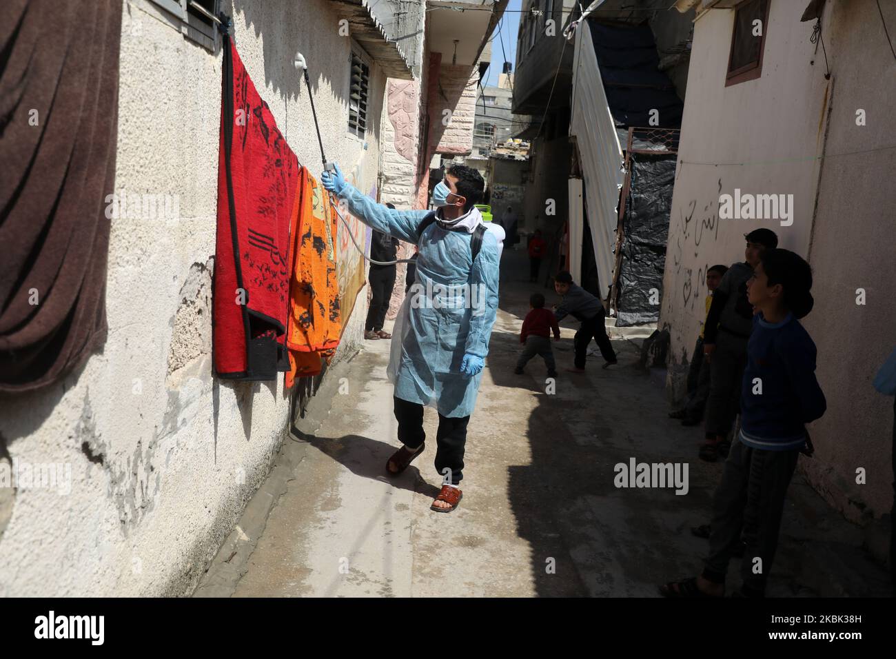 Volontari palestinesi spruzzano disinfettante in una strada nel campo profughi di al-Shati a Gaza City il 16 marzo 2020, durante una campagna di Hamas per arginare una nuova epidemia di coronavirus. – Il movimento islamico Hamas, che governa la striscia di Gaza assediata, ha compiuto l’insolito passo di chiudere i confini con Israele e Egitto come precauzione contro il virus. Finora non vi sono casi documentati di COVID-19 nell'enclave. (Foto di Majdi Fathi/NurPhoto) Foto Stock