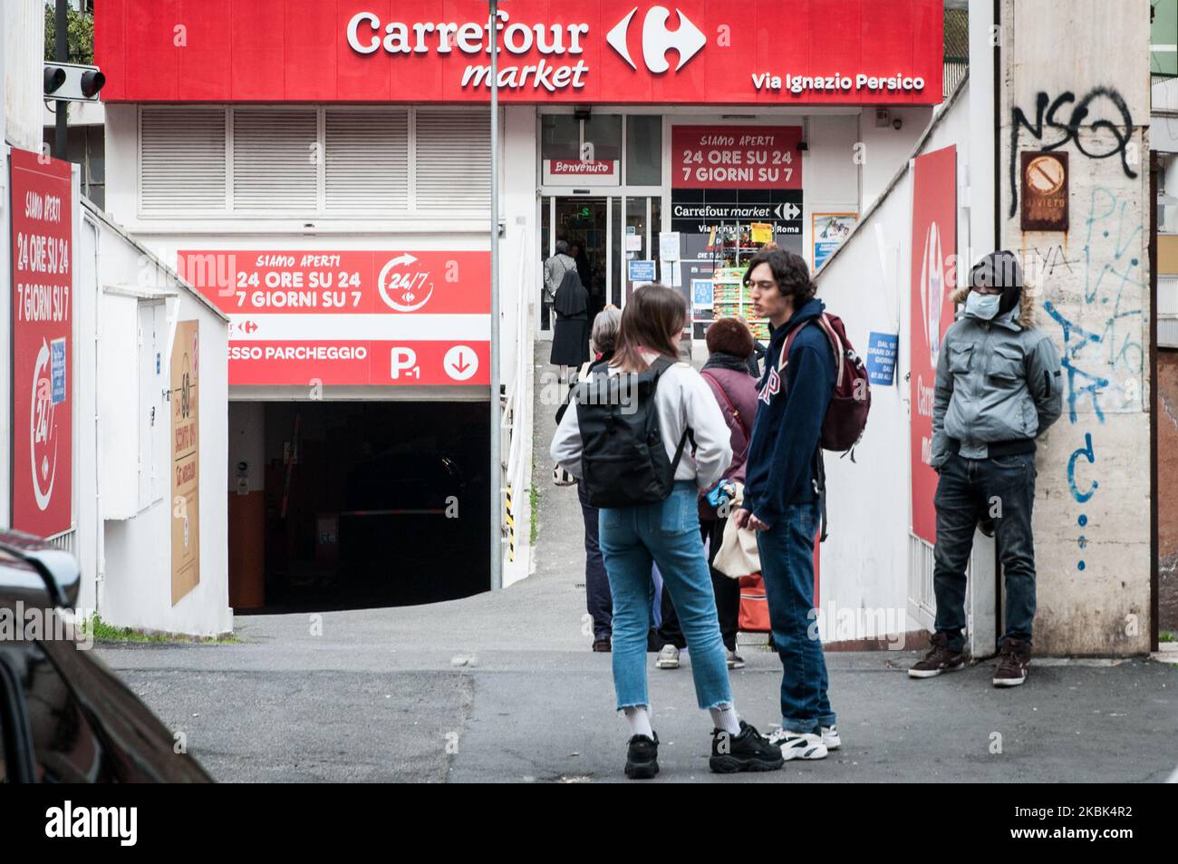 Le persone che si trovano in fila per le prime esigenze di shopping di genere nel quartiere Garbatella il 17 marzo 2020 a Roma. Il governo italiano ha adottato la misura senza precedenti di un blocco a livello nazionale chiudendo tutti i negozi ad eccezione dei servizi essenziali, come farmacie, negozi di alimentari, ferramenta, tabaccherie e banche, nel tentativo di combattere l'epidemia di coronavirus (COVID-19), la seconda più letale al mondo, al di fuori della Cina. I movimenti in entrata e in uscita sono consentiti solo per motivi di lavoro e di salute, comprovati da un certificato medico. Il numero di casi confermati di COVID-19 c Foto Stock