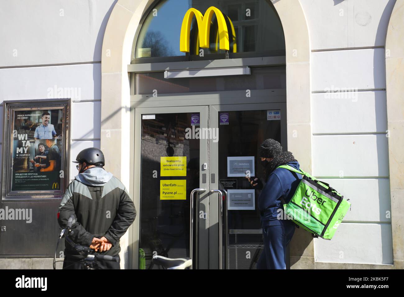 Il conducente di Uber mangia una bicicletta consegna sta ritirando un ordine dal ristorante McDonald's di Cracovia, Polonia, il 17 marzo 2020. A causa della diffusione del coronavirus McDonald's ristorante vendite pasti solo attraverso il servizio di consegna cibo. (Foto di Beata Zawrzel/NurPhoto) Foto Stock