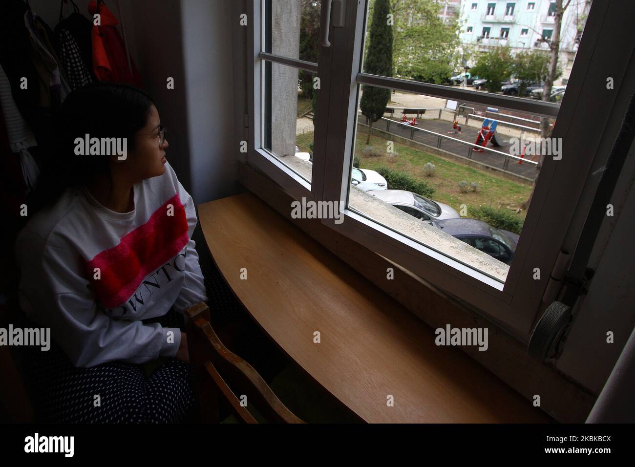 Una donna guarda fuori dalla finestra della sua casa a Lisbona, questo 21st marzo, dopo la dichiarazione di emergenza nazionale che impone una stretta quarantena a tutta la popolazione. Nonostante gli sforzi del governo portoghese per attuare la misura di quarantena per mitigare le infezioni da COVID-19, i cittadini e i turisti non rispettano ancora tali misure. Ci sono state campagne pubblicitarie che invitano i cittadini a rimanere a casa. (Foto di Jorge Mantilla/NurPhoto) Foto Stock