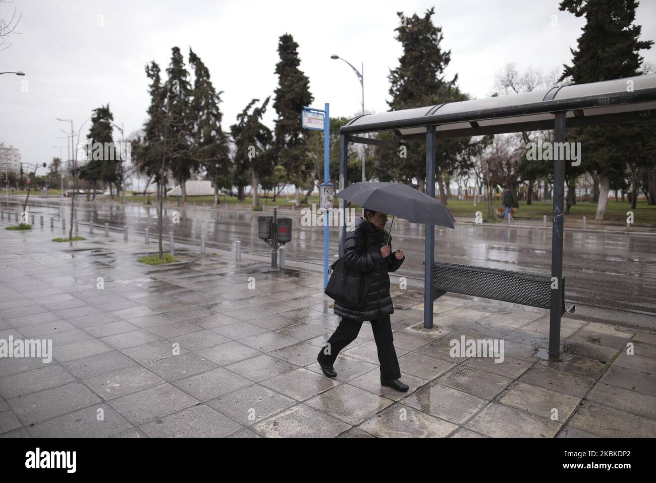 A woman is seen walking next to an empty bus stop, in Thessaloniki, on 23 March 2020. The P.M.of Greece K.Mitsotakis announced the lockdown of the country of Greece starting early at the morning 23 March 2020. (Photo by Achilleas Chiras/NurPhoto) Foto Stock