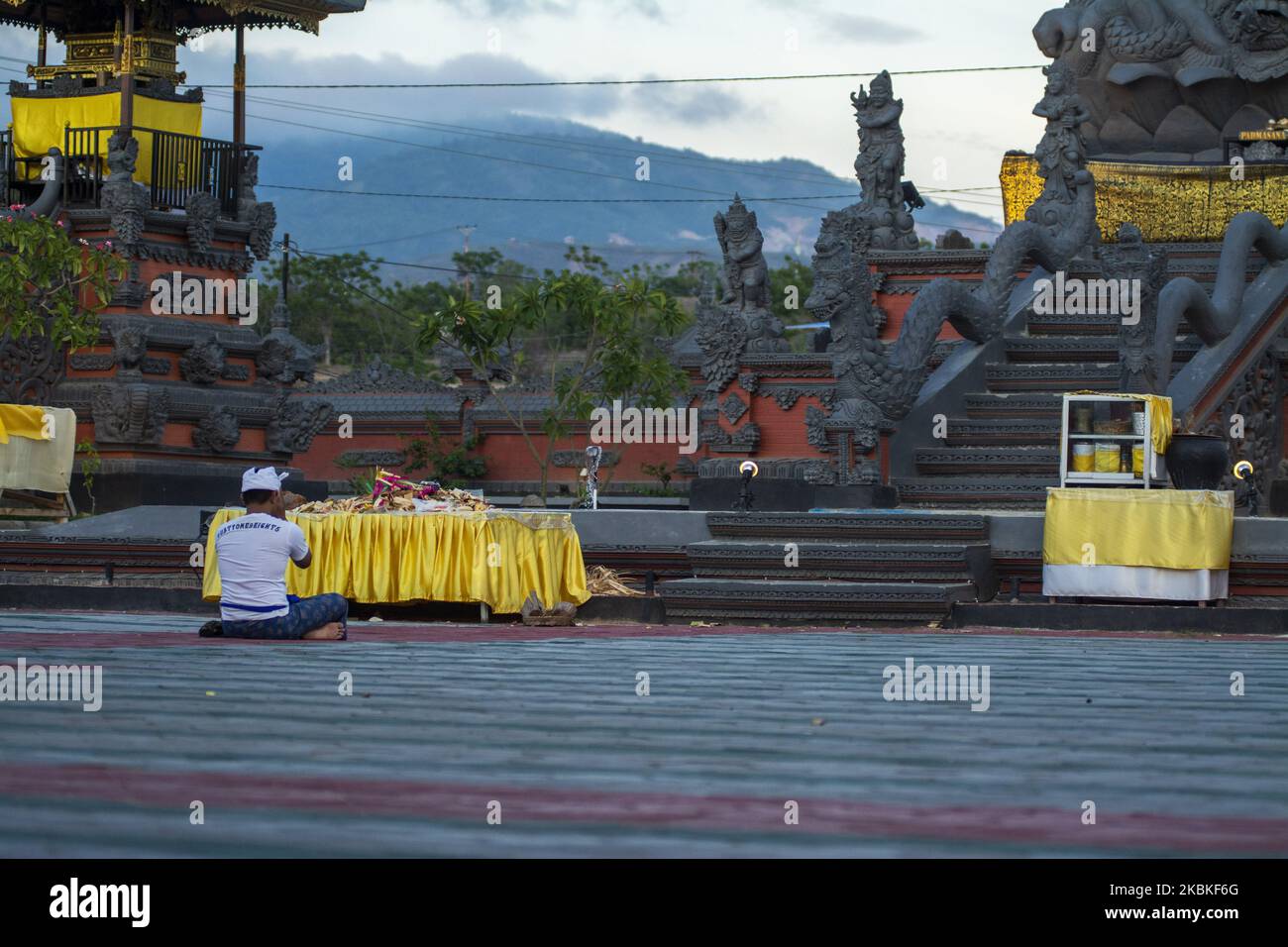 Un indù esegue il suo rituale di preghiera a pura Agung Jagatnatha Wana Kertha, Palu, Sulawesi centrale, Indonesia il 24 marzo 2020. Seguendo il suggerimento del governo, la locale Società indù abolì i rituali di culto congiunti per accogliere il giorno della Seta per prevenire la diffusione del Coronavirus, a meno che non fosse fatto da solo e non in gruppi. Dopo lo scoppio del coronavirus in territorio indonesiano, il governo ha implementato l'allontanamento sociale, l'allontanamento fisico e i luoghi pubblici chiusi, vietando riunioni tra cui lo svolgimento di culto insieme e l'incoraggiamento dei residenti a rimanere a casa. N. Foto Stock