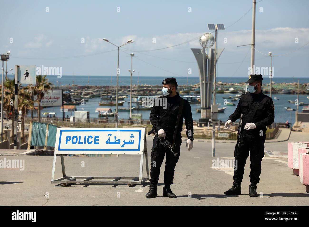Le forze di sicurezza fedeli al movimento islamico palestinese Hamas, che indossa una maschera protettiva, si trova all'ingresso del porto marittimo di Gaza City dopo che è stata chiusa per precauzione contro la diffusione della malattia del coronavirus (COVID-19), a Gaza City 25 marzo 2020. (Foto di Majdi Fathi/NurPhoto) Foto Stock