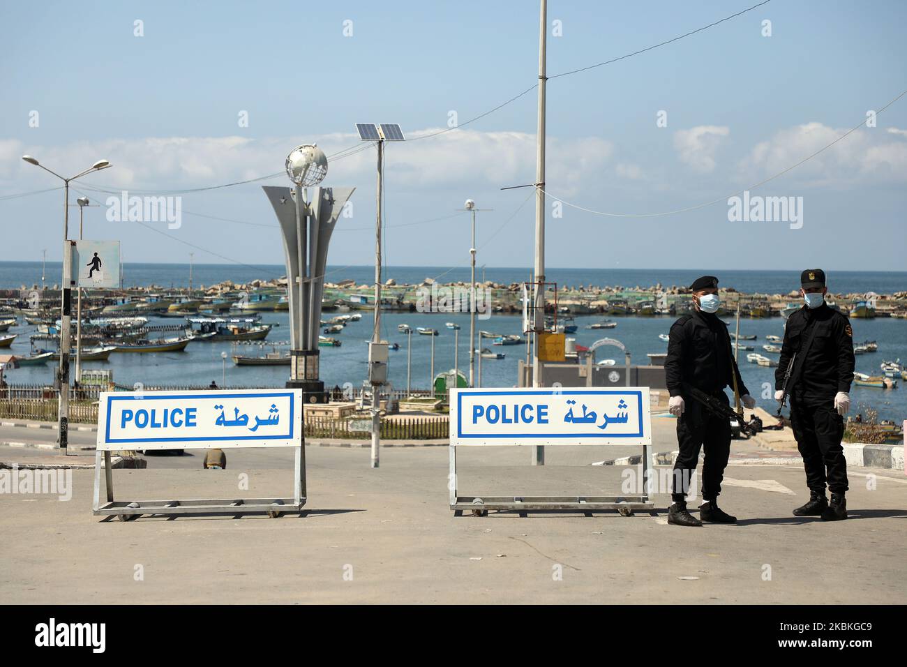 Le forze di sicurezza fedeli al movimento islamico palestinese Hamas, che indossa una maschera protettiva, si trova all'ingresso del porto marittimo di Gaza City dopo che è stata chiusa per precauzione contro la diffusione della malattia del coronavirus (COVID-19), a Gaza City 25 marzo 2020. (Foto di Majdi Fathi/NurPhoto) Foto Stock