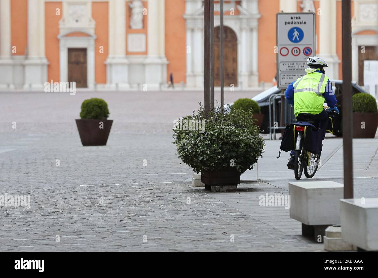 Un postino dell'Ufficio postale italiano consegna la posta in bicicletta nel centro storico durante la pandemia del COVID-19 in Italia il 25 marzo 2020 a Carpi, Italia. (Foto di Emmanuele Ciancaglini/NurPhoto) Foto Stock
