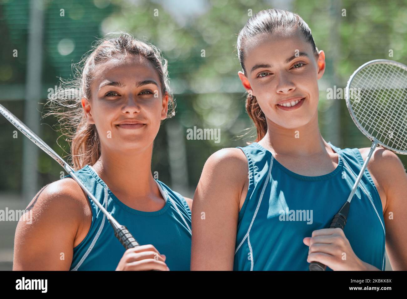 Badminton, donne e squadre sportive in un campo all'aperto pronto per l'esercizio, l'allenamento e il gioco. Ritratto di fitness, allenamento e atleta felice donna Foto Stock