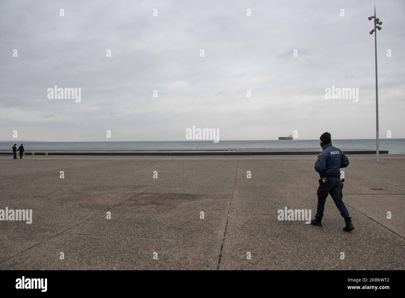 Pattugliamento della polizia a vuoto da parte di persone New Promenade a Salonicco città, Grecia. L'area del lungomare, che include la famosa scultura degli ombrelli, la statua di Alessandro Magno, la Torre Bianca e altri luoghi, sono stati chiusi dalle autorità locali a causa della folla che vi passava nonostante le restrizioni del traffico. Il governo greco e il primo ministro Kyriakos Mitsotakis hanno attuato il blocco nazionale di quarantena del paese con la chiusura di negozi e restrizioni al traffico come una forte misura preventiva contro la diffusione del COVID-19 Coronavirus Pandemic. Grecia Foto Stock