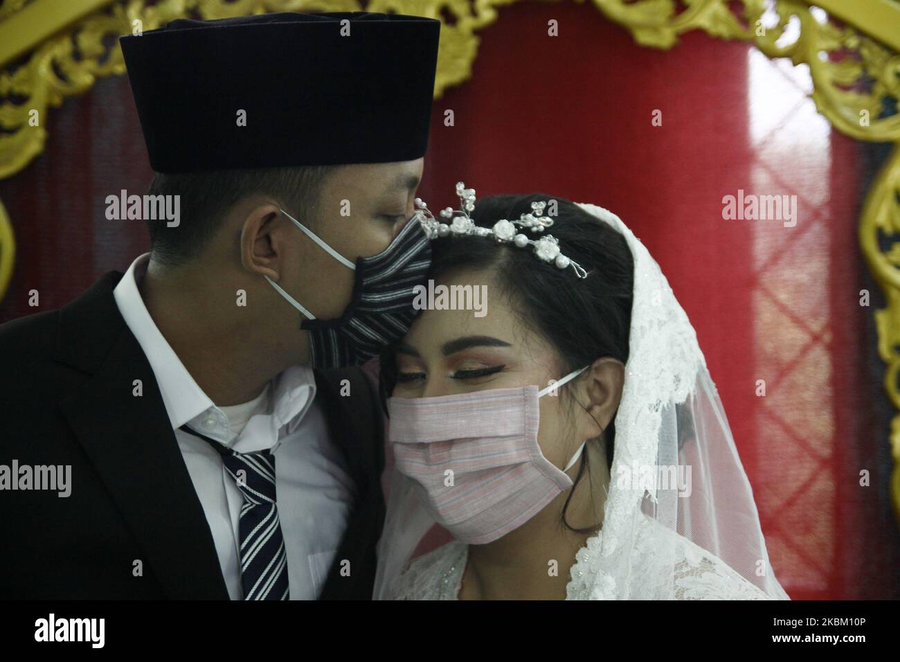 La coppia ha carezzato fuori il loro matrimonio usando la maschera protettiva del viso e guanti di lattice in preoccupazione di coronavirus (Covid-19) a Giacarta, il 5 aprile 2020. Il governo indonesiano ha limitato la politica di allontanamento fisico in seguito al numero di casi di coronavirus in aumento, che a partire da aprile 4 avevano superato i 2,092 casi in tutto il paese, con 191 morti e 150 guariti. (Foto di Aditya Irawan/NurPhoto) Foto Stock