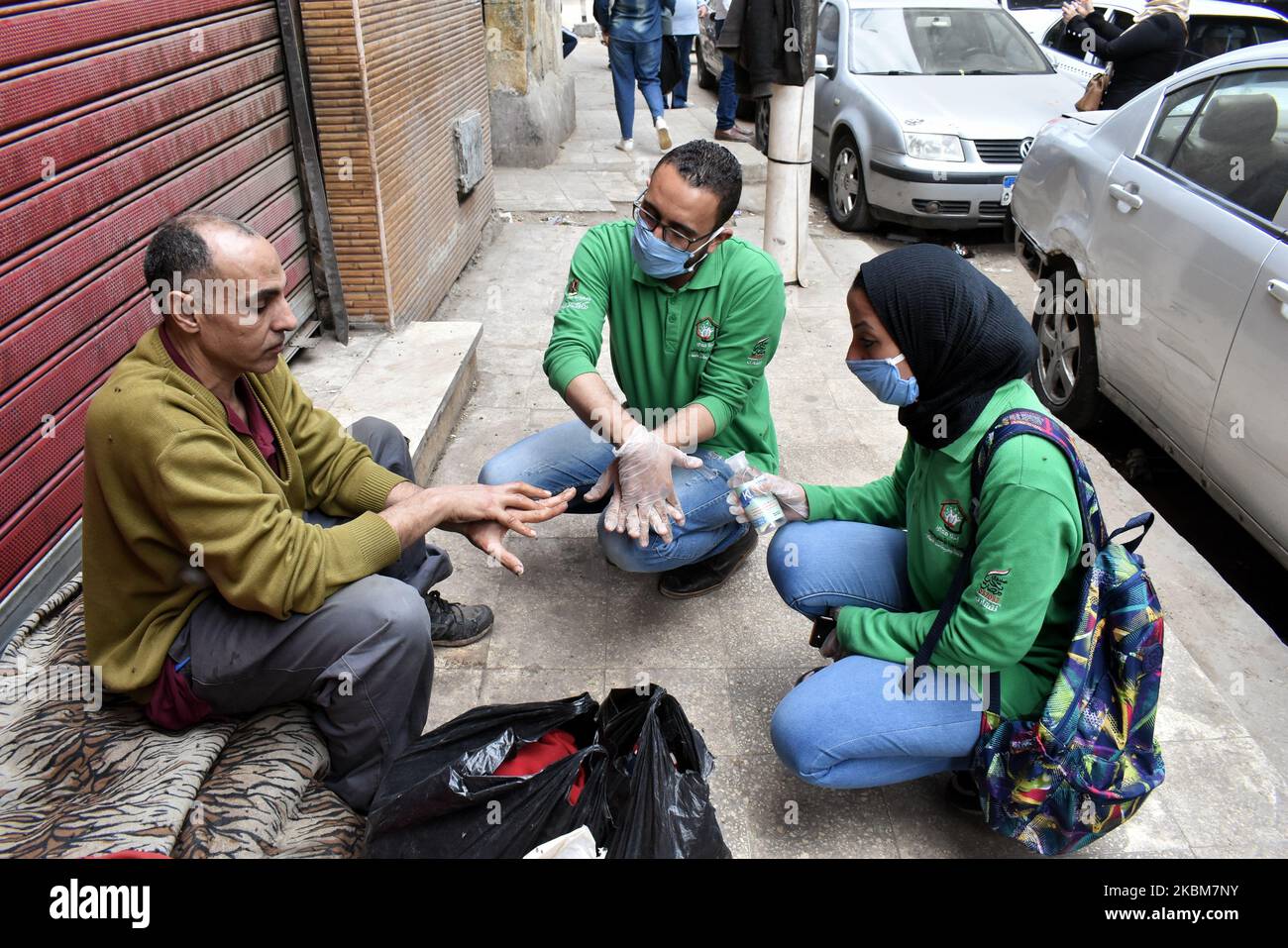 Un uomo spruzza disinfettante dei senzatetto, e questo è venuto come parte del 'Siamo con voi' intimo per limitare la diffusione del coronavirus (covid19), in una campagna per sterilizzare le persone senza tetto nelle strade del Cairo Egitto, 9April. (Foto di Ziad Ahmed/NurPhoto) Foto Stock