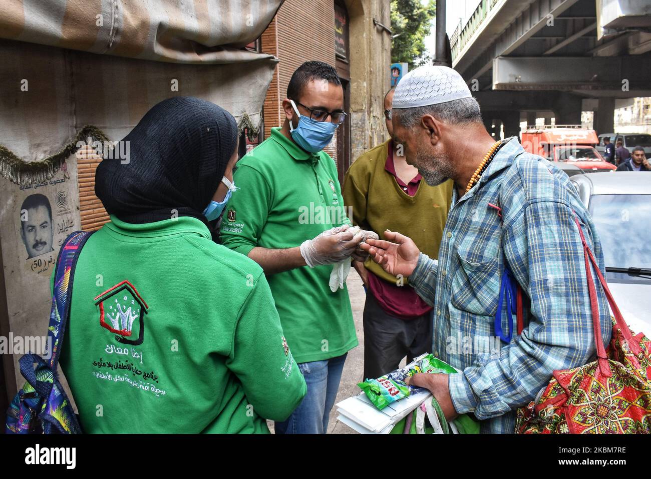 L'uomo spruzza disinfettante dei senzatetto, e questo è venuto come parte del 'Siamo con voi' intimo per limitare la diffusione del coronavirus (covid19), in una campagna per sterilizzare le persone senza tetto nelle strade del Cairo Egitto, 9April. (Foto di Ziad Ahmed/NurPhoto) Foto Stock