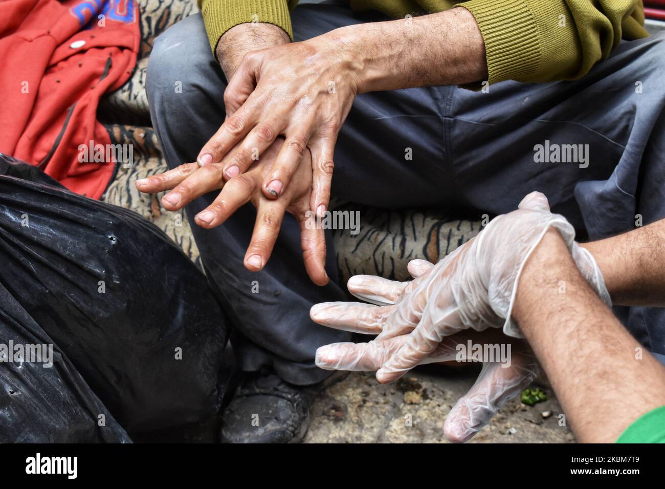 L'uomo spruzza disinfettante dei senzatetto, e questo è venuto come parte del 'Siamo con voi' intimo per limitare la diffusione del coronavirus (covid19), in una campagna per sterilizzare le persone senza tetto nelle strade del Cairo Egitto, 9April. (Foto di Ziad Ahmed/NurPhoto) Foto Stock