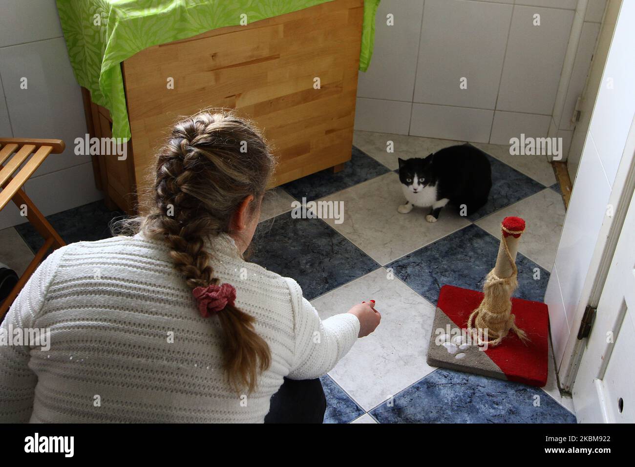 Una donna gioca con il suo gatto durante le giornate di quarantena in un edificio a Lisbona, il 10 aprile 2020. La Guardia Nazionale Repubblicana portoghese e i gruppi di protezione degli animali hanno lanciato campagne di sensibilizzazione per incoraggiare le persone a non abbandonare gli animali domestici a causa del COVID-19, poiché un numero considerevole di animali è stato lasciato al loro destino a causa dei timori di poter trasmettere la malattia. Tuttavia, nuove prove indicano che i gatti possono essere infettati con il nuovo coronavirus. Le informazioni sono state fornite dall'Harbin Veterinary Research Institute, il principale organismo di ricerca sugli animali in Cina. (Foto di Jorg Foto Stock