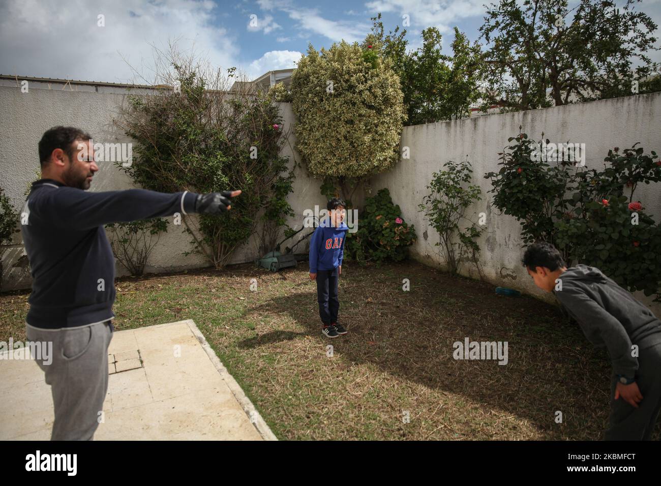 Un padre che si riferisce ad un combattimento di karate tra i suoi due figli adolescenti, nel cortile di casa, nel governatorato di Ariana, nel nord della Tunisia, mentre cercano di scacciare la vacuità, Lo stress e di rimanere in forma durante il blocco generale imposto dalle autorità tunisine nel tentativo di rallentare la diffusione del nuovo focolaio di coronavirus che causa la malattia di Covid-19 in Tunisia, il 26 marzo 2020. (Foto di Chardy ben Ibrahim/NurPhoto) Foto Stock