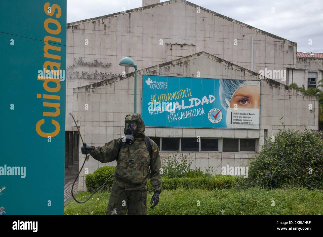 Un soldato si disinfetta di fronte a un cartello all'ingresso del recinto del Covadonga Sanatorium che recita ''We take care''. Le truppe dell'esercito spagnolo hanno svolto lavori di disinfezione presso il Sanatorium Covadonga, una residenza privata che accoglie diversi pazienti affetti da coronavirus, a Gijón, in Spagna, il 17 aprile 2020. Questi lavori fanno parte dell'operazione Balmis lanciata dal governo per la collaborazione delle forze armate nella lotta contro la pandemia di coronavirus. In questo quadro, sono stati mobilitati fino a 90.000 soldati, con una media di 550 interventi giornalieri focalizzati Foto Stock