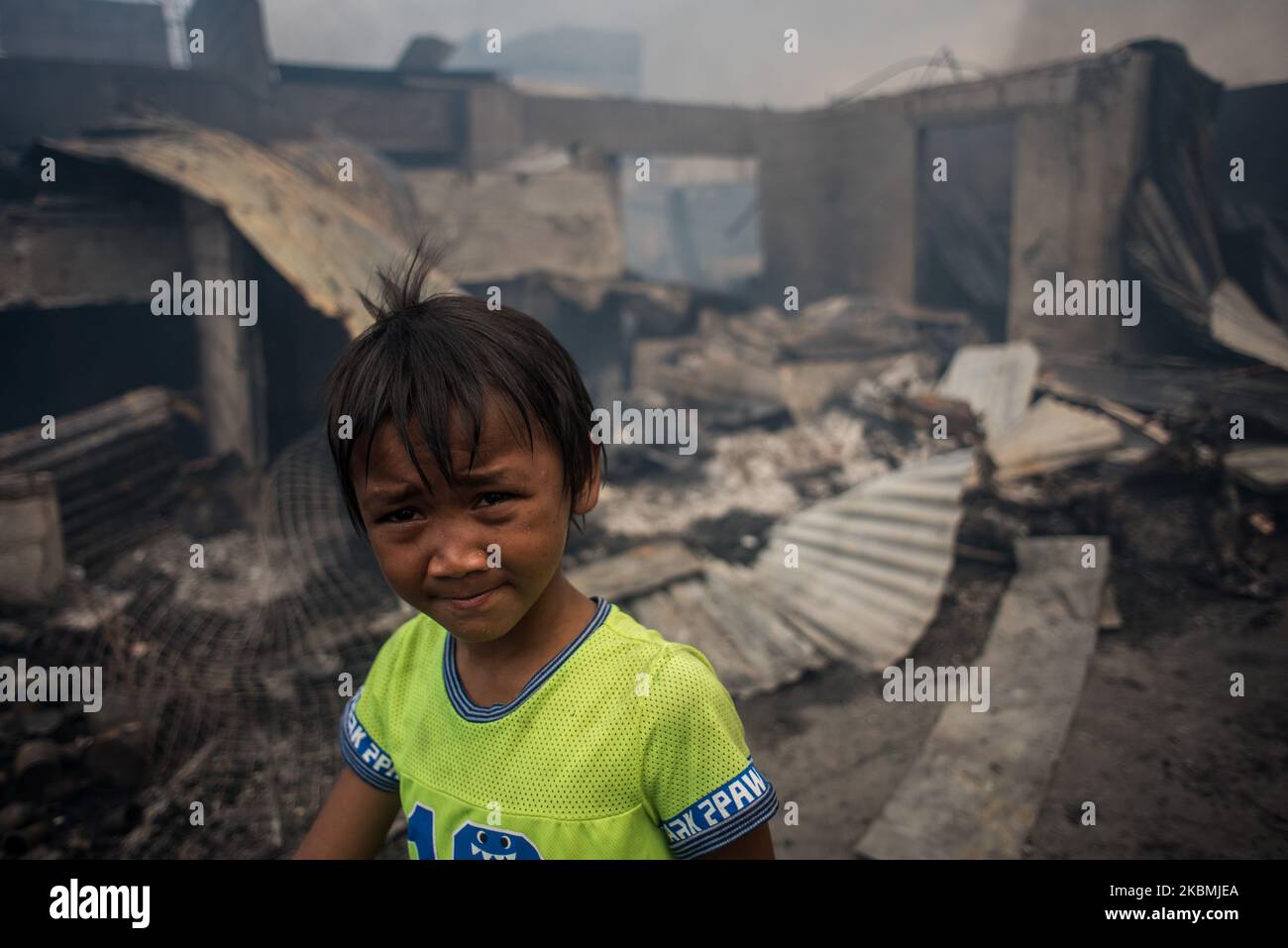 Un ragazzo passa davanti a diverse case distrutte dopo che un incendio scoppiò in una zona baraccata a Tendo, Manila, nelle Filippine, il 18 aprile 2020. Circa 500 famiglie hanno perso le loro case, mentre Manila e l'intera isola di Luzon rimangono in quarantena. Il numero di casi COVID-19 confermati nel paese supera i 6.000.(Foto di Lisa Marie David/NurPhoto) Foto Stock