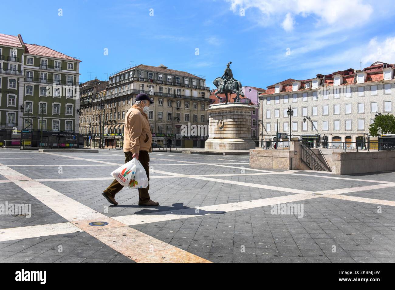 Un uomo che indossa una maschera protettiva cammina vicino a Piazza Pedro  IV, Lisbona, Portogallo, 18 aprile 2020. Il Portogallo sta valutando la  possibilità di rendere obbligatorio l'uso di maschere protettive sui