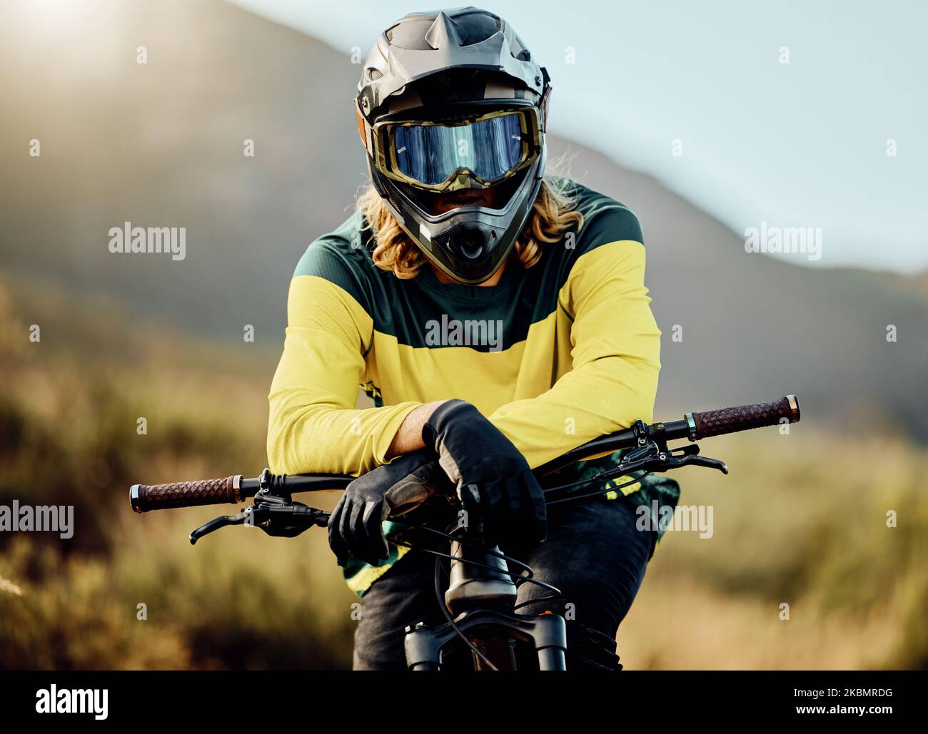 Bici da terra, bicicletta e ritratto dell'atleta da guidare in gara ciclistica competitiva per l'avventura. Sport estremi, moto e motociclista in attesa di andare in bicicletta Foto Stock