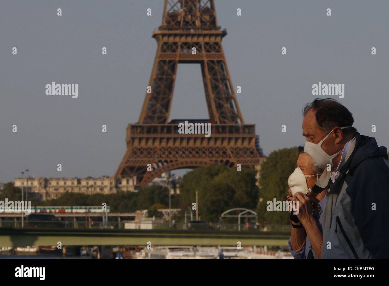 Una coppia a piedi sul ponte Mirabeau un fronte la Torre Eiffel a Parigi, il 23 aprile 2020 a Parigi, Francia. La pandemia di Coronavirus (COVID-19) si è diffusa in molti paesi del mondo. Foto Stock