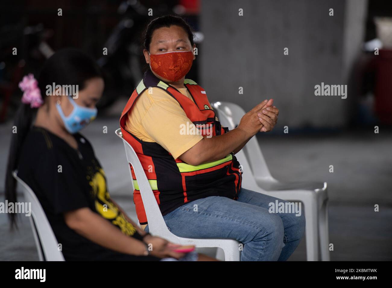 Un tassista motociclista membro della comunità che indossa una maschera viso comunità utilizzare disinfettante per le mani mentre si sta per ricevere cibo a Khlong Toei comunità il 24 aprile 2020 a Bangkok, Thailandia. A causa di molte persone nella comunità hanno perso lavoro e reddito, con conseguente mancanza di reddito nella vita quotidiana. (Foto di Vachira Vachira/NurPhoto) Foto Stock