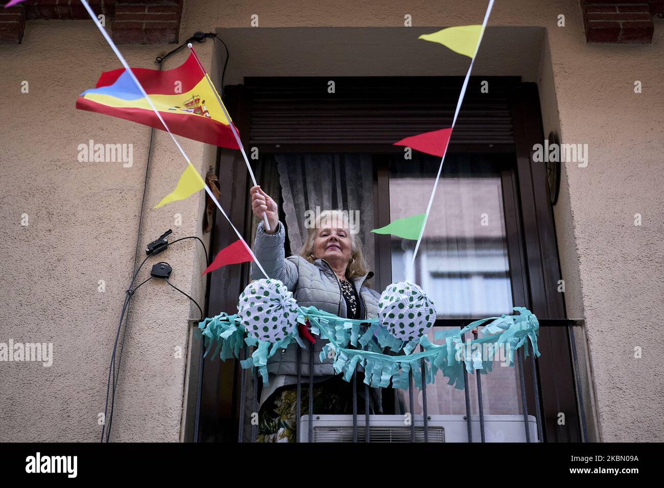 Vicini della via Maria Panes a Madrid decorano la strada in occasione dell'inizio della 'Feria de Abril' a Siviglia con musica, bevande e bandiere spagnole a Madrid, Spagna il 25 aprile 2020. (Foto di A. Ware/NurPhoto) Foto Stock