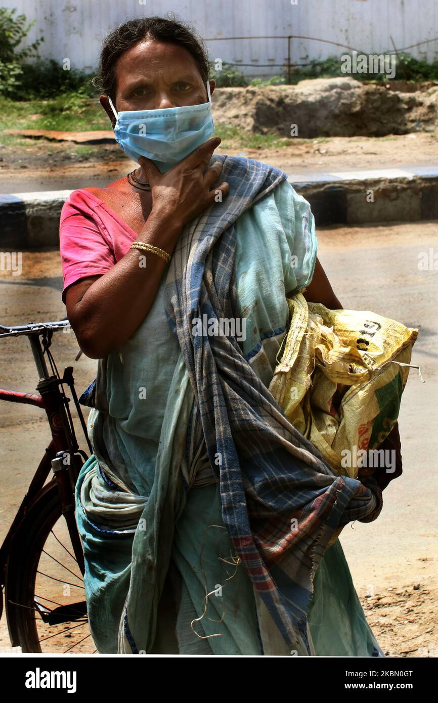 Persone in attesa di ricevere cibo gratuito durante il blocco nazionale a Kolkata, India, Lunedi, 27 aprile 2020. Mentre i governi di tutto il mondo cercano di rallentare la diffusione del coronavirus, l’India ha lanciato uno degli esperimenti sociali più draconiani della storia, bloccando tutta la sua popolazione, tra cui circa 176 milioni di persone che lottano per sopravvivere con $1,90 dollari al giorno o meno. (Foto di Debajyoti Chakraborty/NurPhoto) Foto Stock