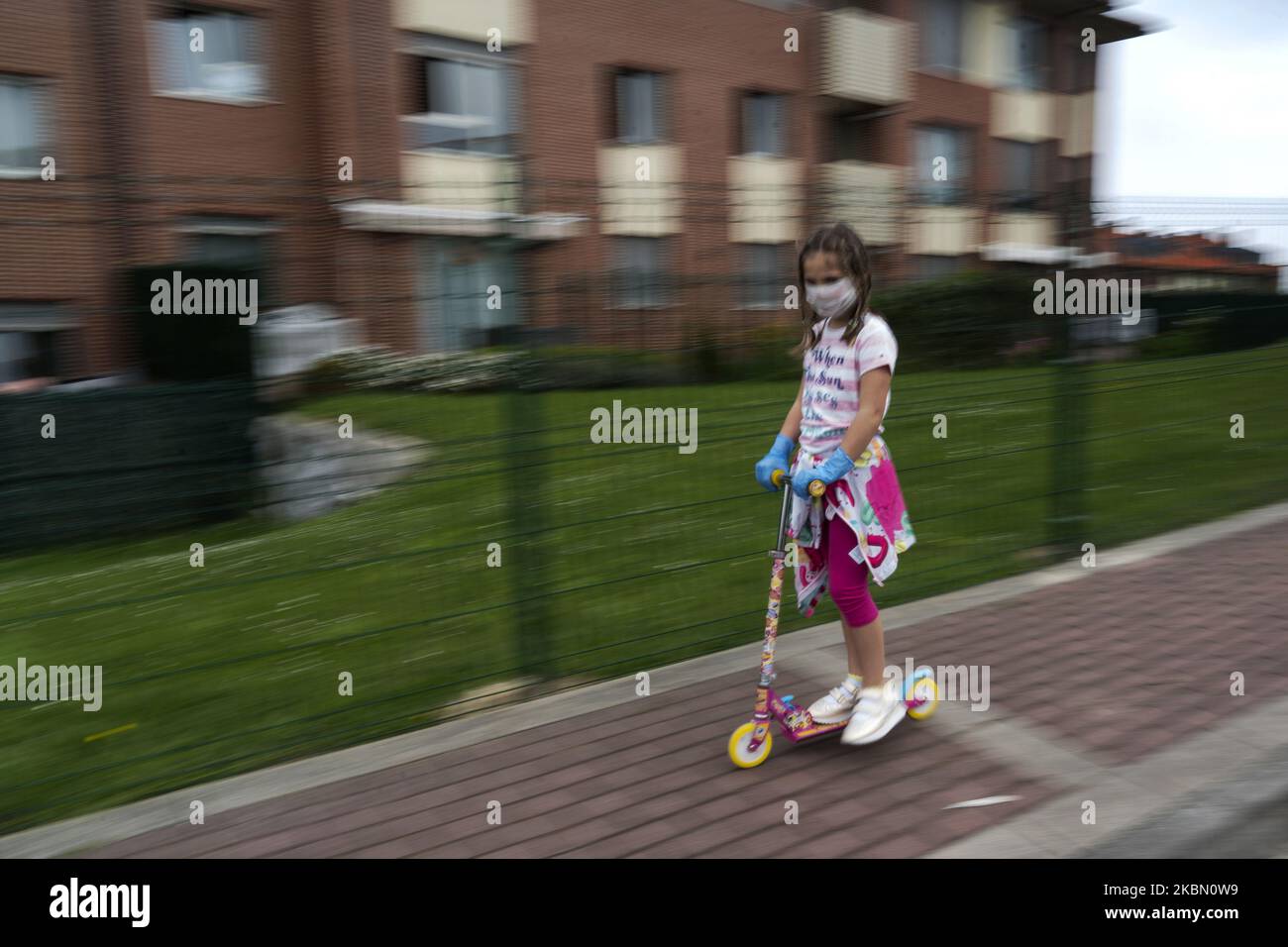 Una ragazza gioca con il suo scooter durante il primo giorno che i bambini sono rilasciati di nuovo dopo 42 giorni confinati dalla quarantena obbligatoria decretata dal governo a seguito del coronavirus (Covid-19) a Santander, Spagna il 26 aprile 2020. (Foto di Joaquin Gomez Sastre/NurPhoto) Foto Stock