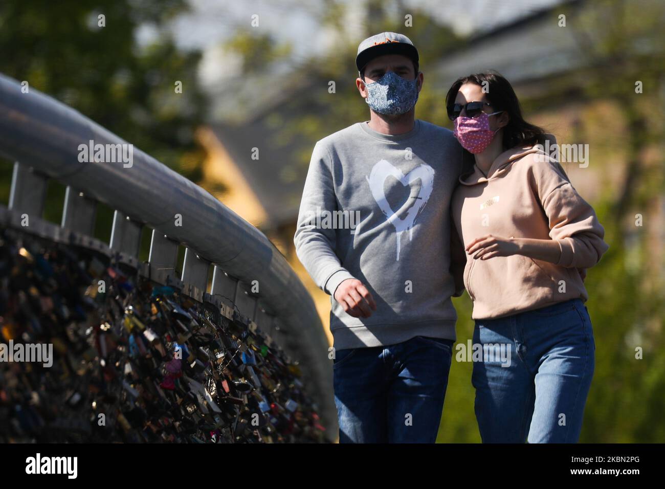 Una coppia indossa una maschera protettiva a causa della diffusione del coronavirus. Cracovia, Polonia il 27 aprile 2020. La regola di coprire il naso e la bocca in luoghi pubblici con maschere facciali, intarsi o fazzoletti è entrata in vigore dall'aprile 16th. L'ordine non si applica ai bambini fino all'età di due anni e alle persone che non sono in grado di coprire la bocca o il naso a causa di difficoltà respiratorie. (Foto di Beata Zawrzel/NurPhoto) Foto Stock