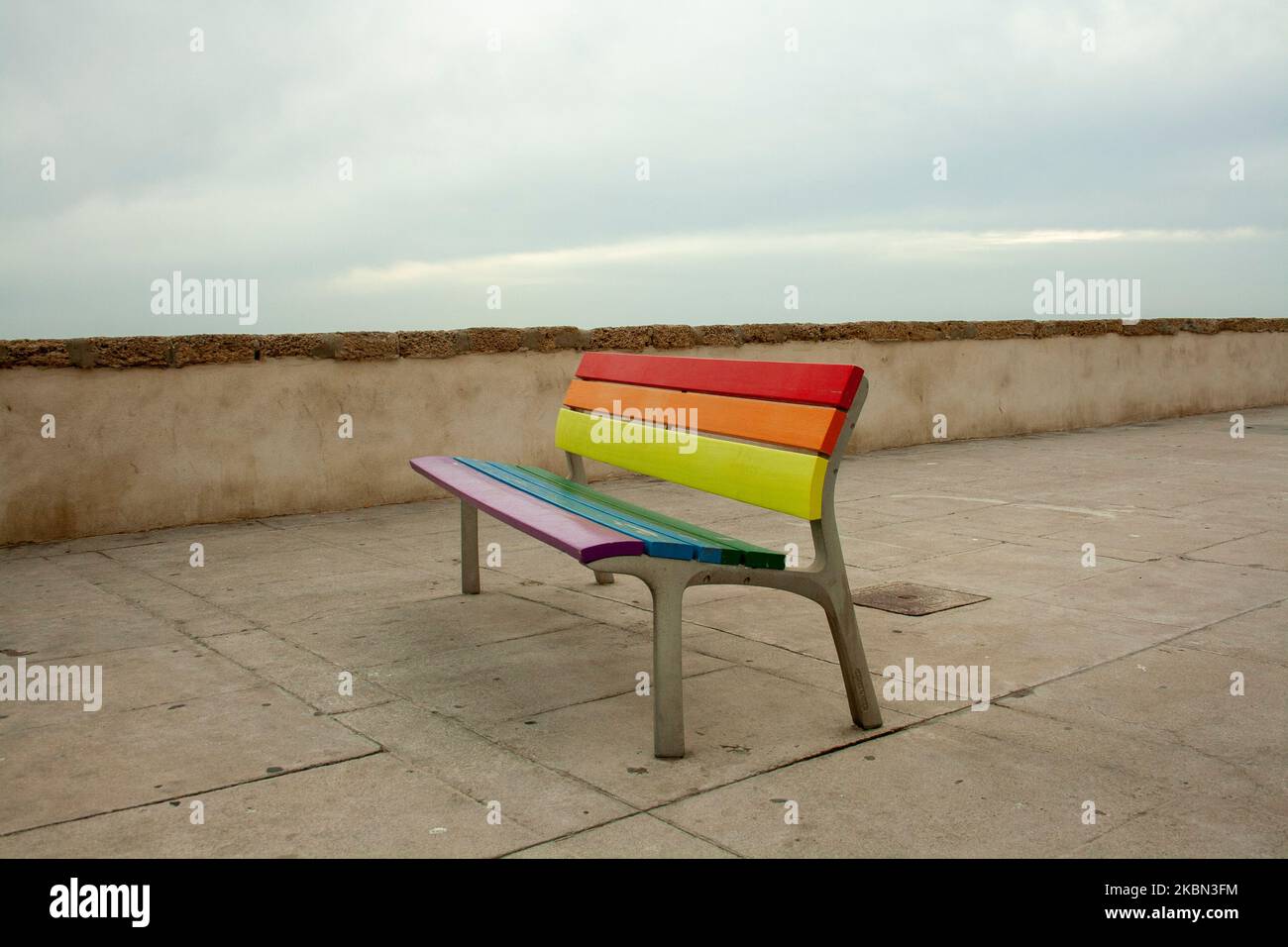 Panchine colorate sul lungomare della città di Cadice in Spagna che rappresentano il concetto di orgoglio gay LGTBY Foto Stock