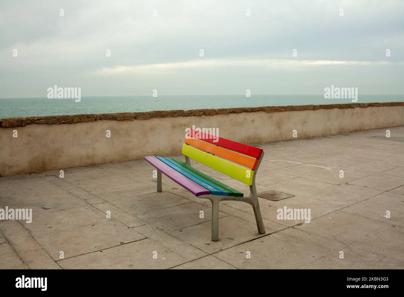 Panchine colorate sul lungomare della città di Cadice in Spagna che rappresentano il concetto di orgoglio gay LGTBY Foto Stock