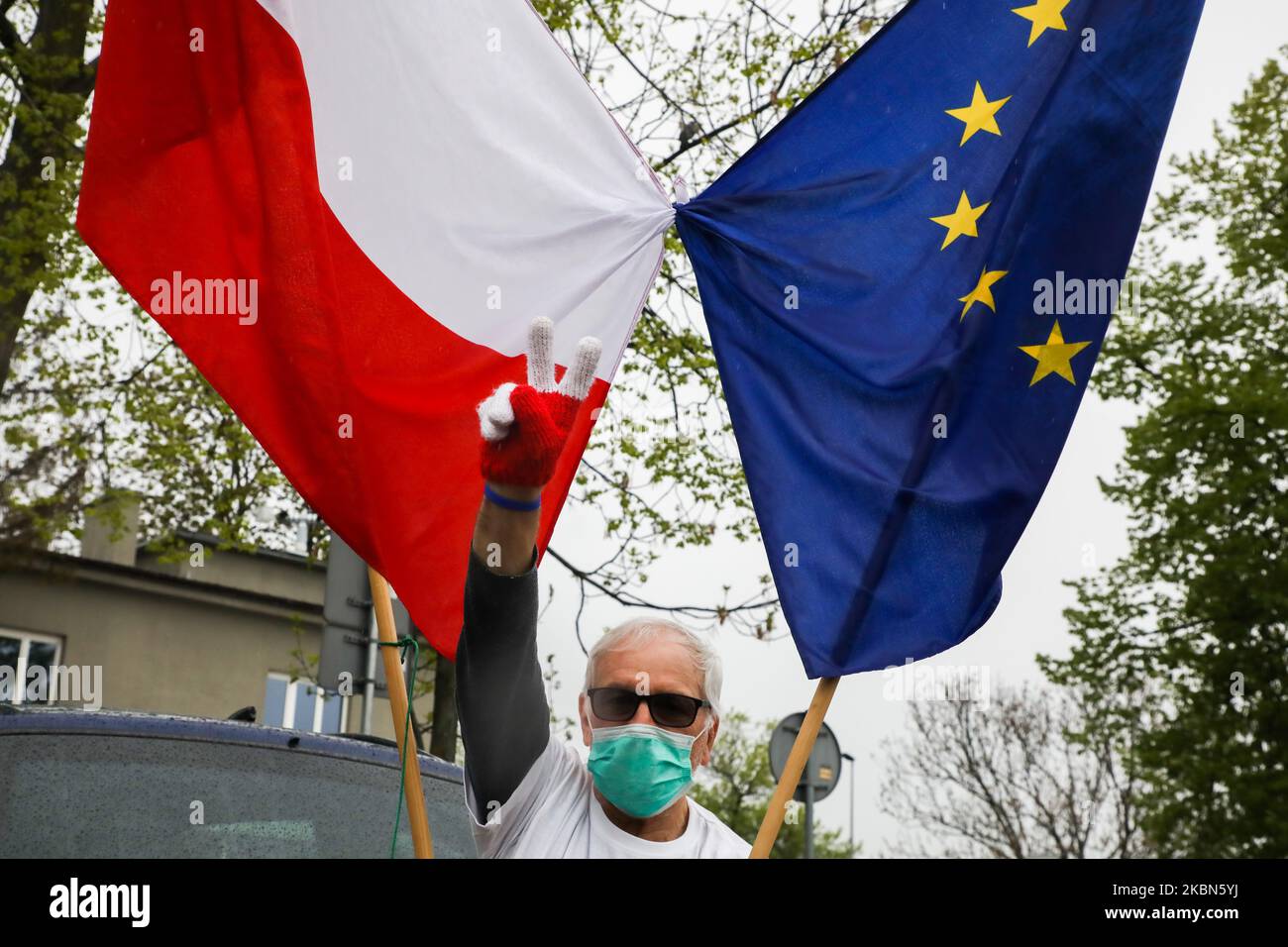 Un uomo che indossa una maschera chirurgica partecipa a una manifestazione automobilistica che celebra il 16th° anniversario dell'adesione della Polonia all'Unione europea e protesta contro i piani di governo per tenere le elezioni presidenziali il 10 maggio sotto forma di voto per corrispondenza, nonostante la pandemia del coronavirus. Cracovia, Polonia il 1st maggio 2020. (Foto di Beata Zawrzel/NurPhoto) Foto Stock