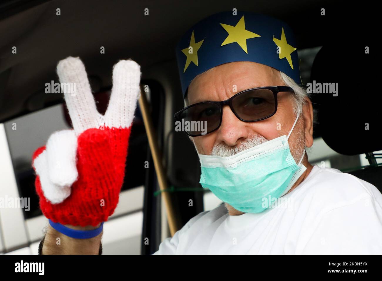 Un uomo che indossa una maschera chirurgica partecipa a una manifestazione automobilistica che celebra il 16th° anniversario dell'adesione della Polonia all'Unione europea e protesta contro i piani di governo per tenere le elezioni presidenziali il 10 maggio sotto forma di voto per corrispondenza, nonostante la pandemia del coronavirus. Cracovia, Polonia il 1st maggio 2020. (Foto di Beata Zawrzel/NurPhoto) Foto Stock