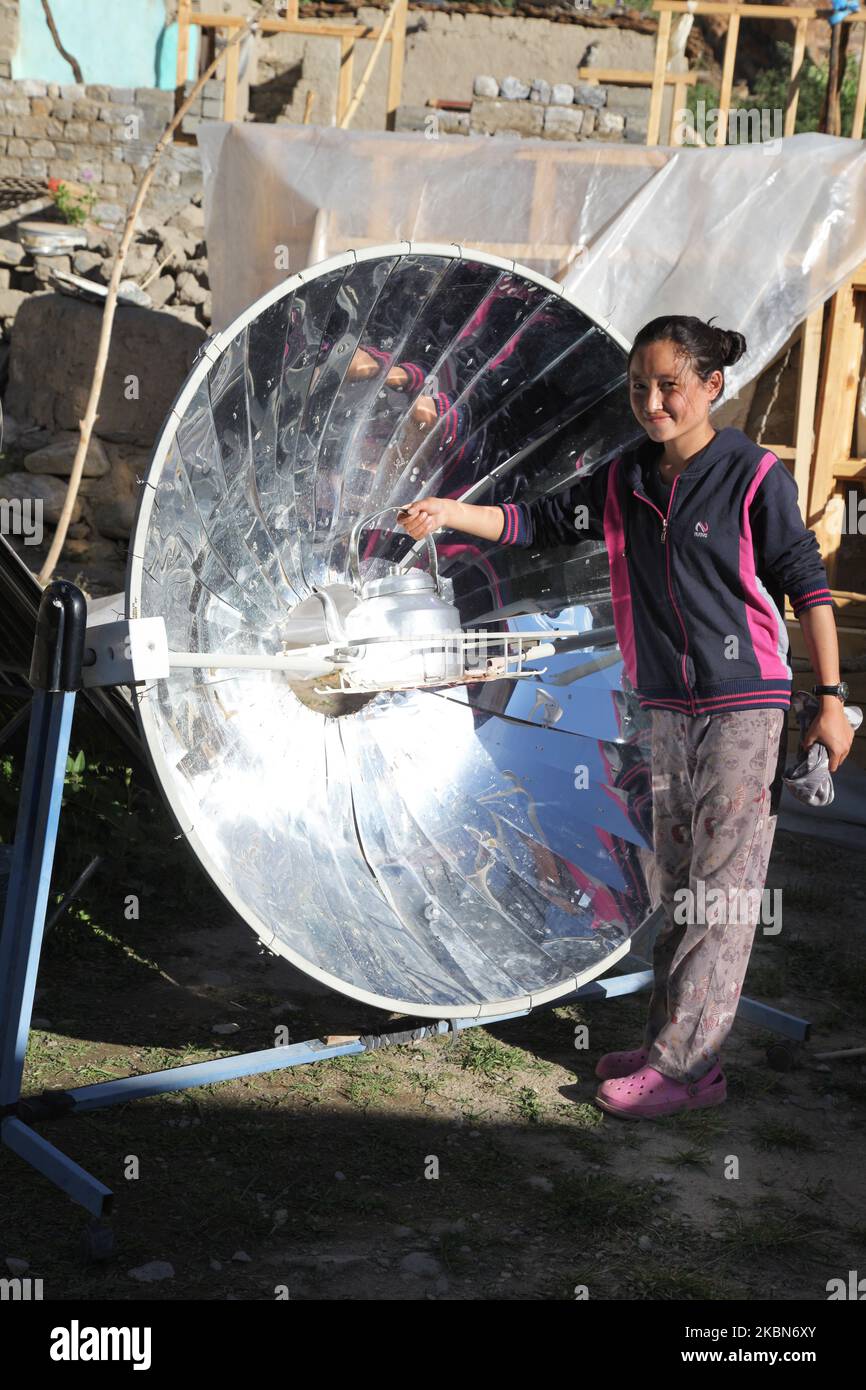 La ragazza Ladakhi usa un fornello solare parabolico per riscaldare l'acqua per il tè fuori della sua casa nel piccolo villaggio di Tangtse, Ladakh, Jammu e Kashmir, India. (Questa immagine ha un modello firmato disponibile) (Foto di Creative Touch Imaging Ltd./NurPhoto) Foto Stock