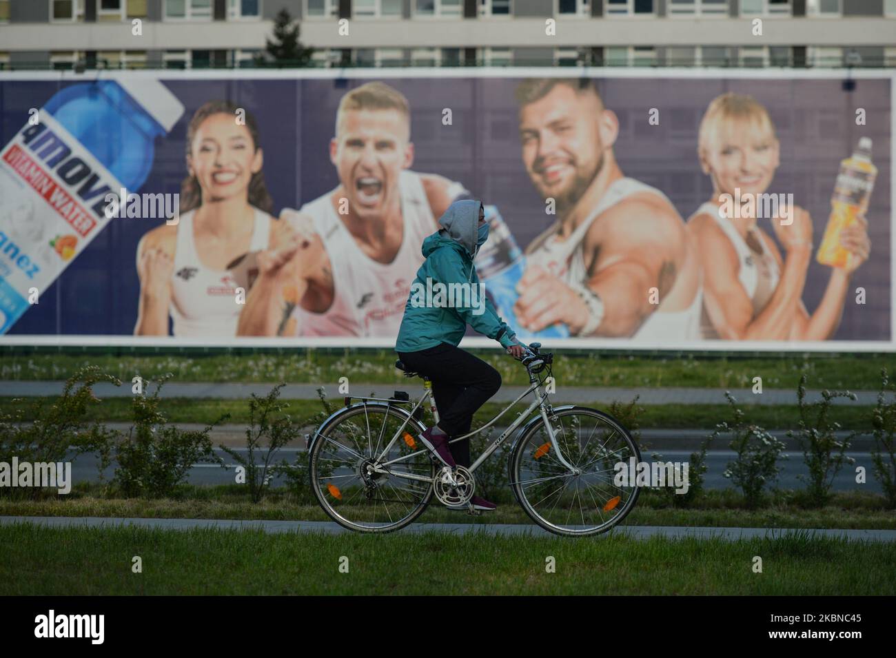 Un ciclista che indossa una maschera protettiva passa per immagini di atleti polacchi (L-R) Sofia Ennaoui, Marcin Lewandowski, Konrad Bukowiecki e Justyna Swiety-Erseic, visti sul banner promozionale isotonico 4Move (prodotto da FoodCare), a Cracovia. Martedì 5 maggio 2020, a Cracovia, Polonia. (Foto di Artur Widak/NurPhoto) Foto Stock