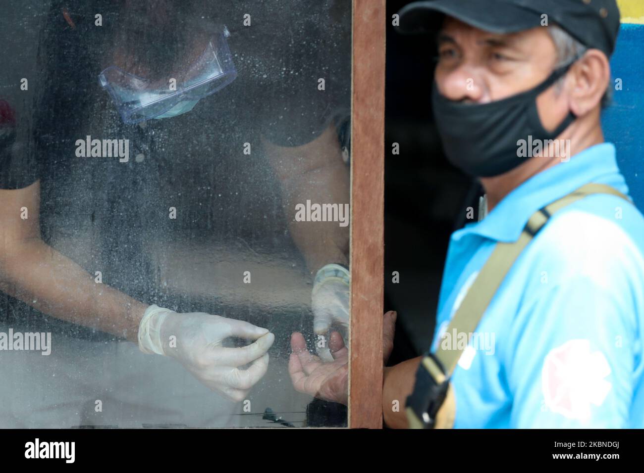 Gli operatori sanitari effettuano test rapidi su funzionari locali del villaggio in una comunità a Mandaluyong City, ad est di Manila, il 7 maggio 2020. Un'area della città è stata posta sotto "blocco totale" dal maggio 7 al maggio 13 per frenare la diffusione di COVID19 nella zona che è considerata una zona rossa dal governo locale. Le Filippine hanno recentemente registrato 10.004 casi confermati su COVID19, e hanno raggiunto un totale di 658 vittime a causa della malattia. (Foto di George Calvelo/NurPhoto) Foto Stock