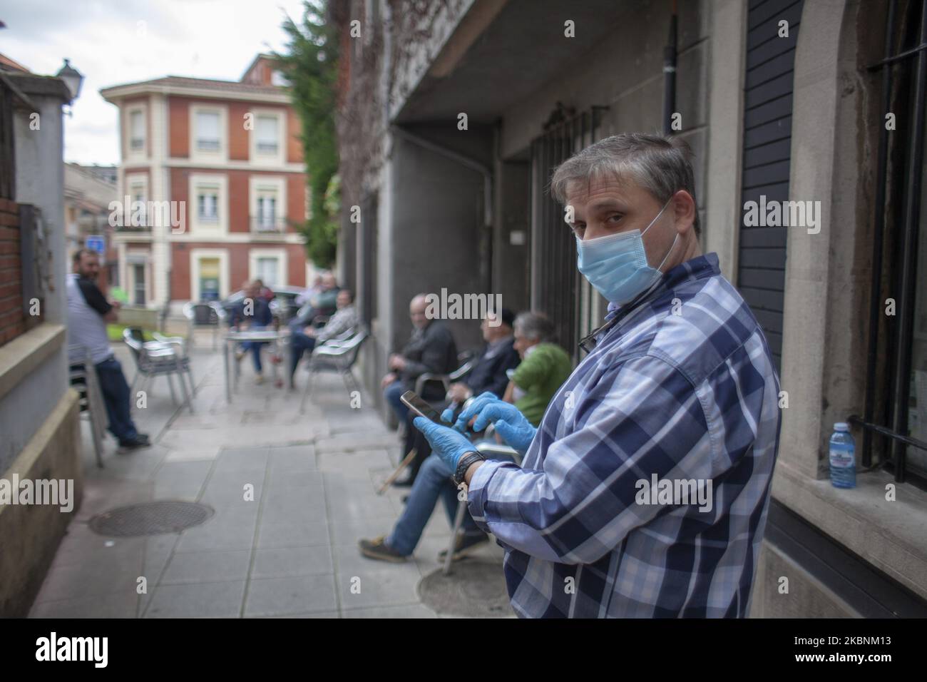 Il proprietario del bar El Retiro assiste agli ordini dei suoi clienti il primo giorno di apertura durante la crisi a causa del covid 19, a Norena, Spagna il 11 maggio 2020. Hanno aperto le prime terrazze del settore alberghiero in Spagna, con il 50% della sua capacità, e con un'area riservata agli anziani. Non può essere consumato all'interno. E si mantiene una distanza sociale di almeno due metri tra i tavoli o i gruppi di tavoli, in cui possono essere servite solo 10 persone al massimo. Tra un cliente e l'altro, le tabelle e tutte quelle superfici di contatto per uso condiviso saranno disinfettate, l'uso o Foto Stock