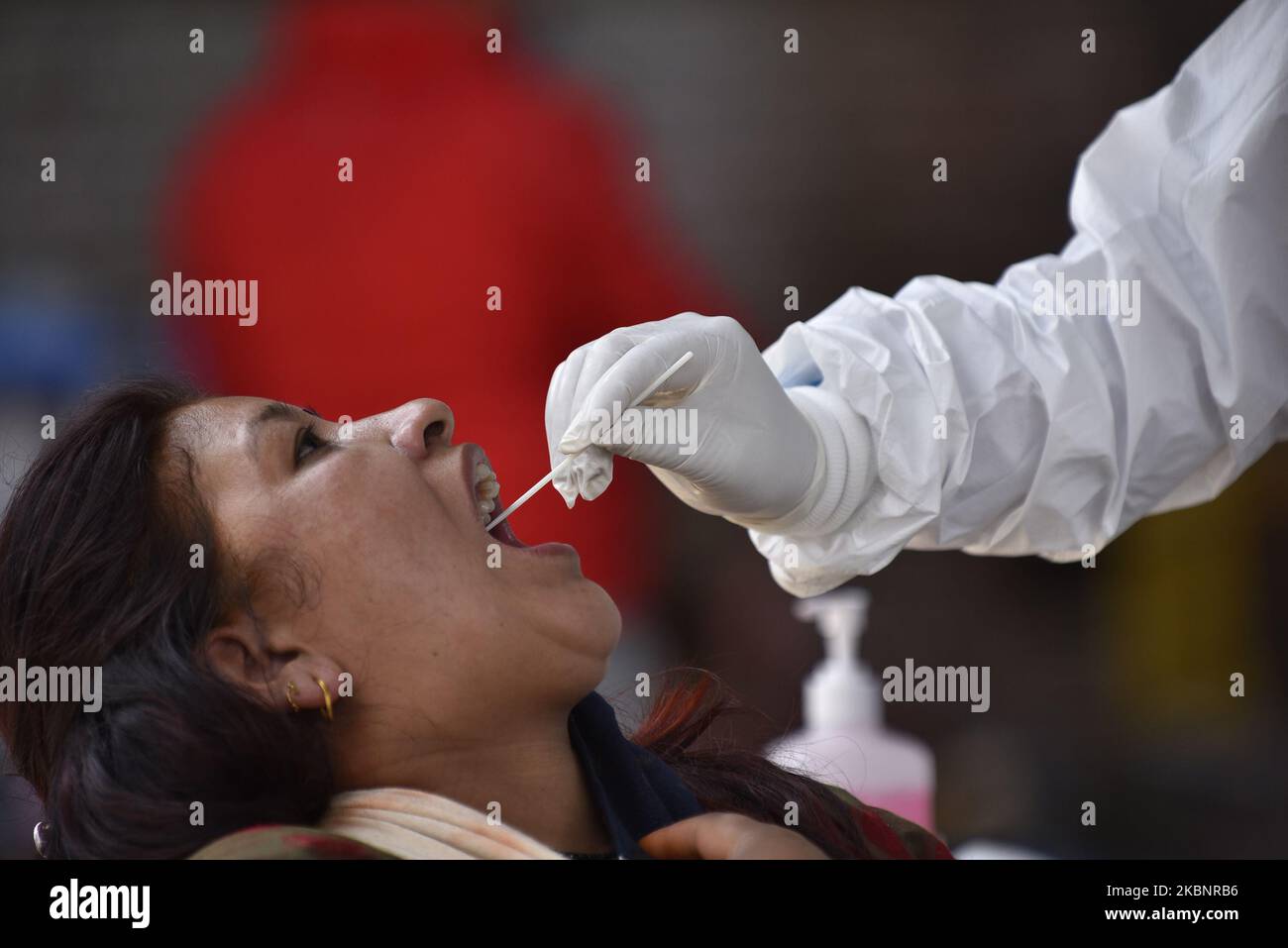 Un personale sanitario nepalese preleva un campione di tampone orale del venditore di verdure per un test di reazione a catena della polimerasi del coronavirus (PCR) nel mercato dei frutti e delle verdure di Kalimati, Kathmandu, Nepal giovedì 14 maggio 2020. (Foto di Narayan Maharjan/NurPhoto) Foto Stock