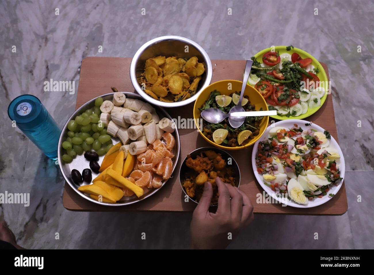 Spuntini e frutta sono tenuti per rompere velocemente da un uomo musulmano a Gurugram nella periferia di Nuova Delhi, India il 17 maggio 2020. (Foto di Nasir Kachroo/NurPhoto) Foto Stock