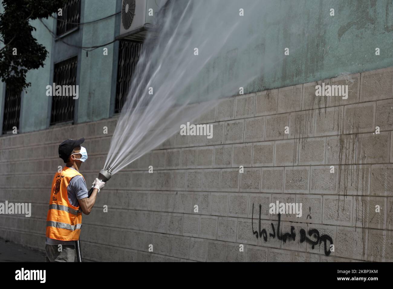 Un lavoratore palestinese che indossa un equipaggiamento protettivo, disinfetta le pareti all'esterno di una moschea, in mezzo alle preoccupazioni circa la diffusione della malattia di coronavirus (COVID-19), a Gaza City 21 maggio 2020. (Foto di Majdi Fathi/NurPhoto) Foto Stock
