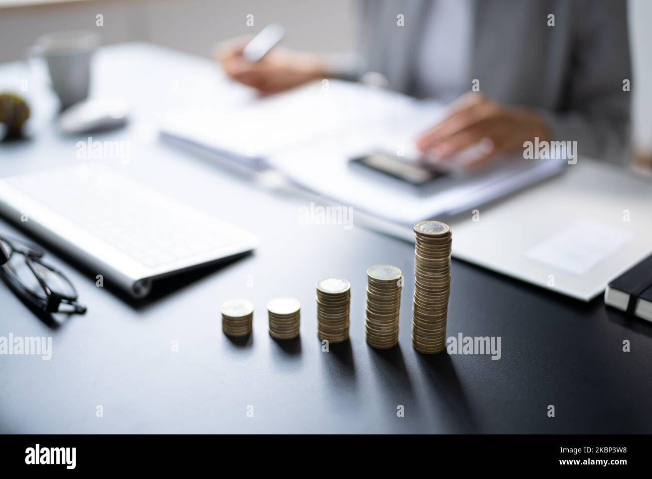 African Accountant Using Calculator. Soldi e monete fiscali Foto Stock