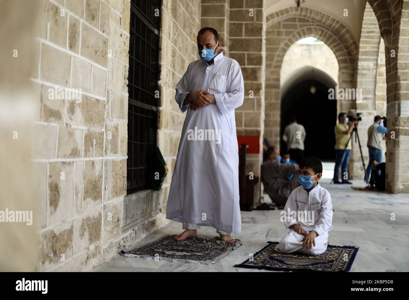 I palestinesi che indossano maschere assistono alle preghiere del venerdì in una moschea mentre i luoghi santi si riaprono ai fedeli per eseguire il rituale islamico settimanale, in mezzo alla preoccupazione per la diffusione della malattia di coronavirus (COVID-19), a Gaza City, 22 maggio 2020. (Foto di Majdi Fathi/NurPhoto) Foto Stock