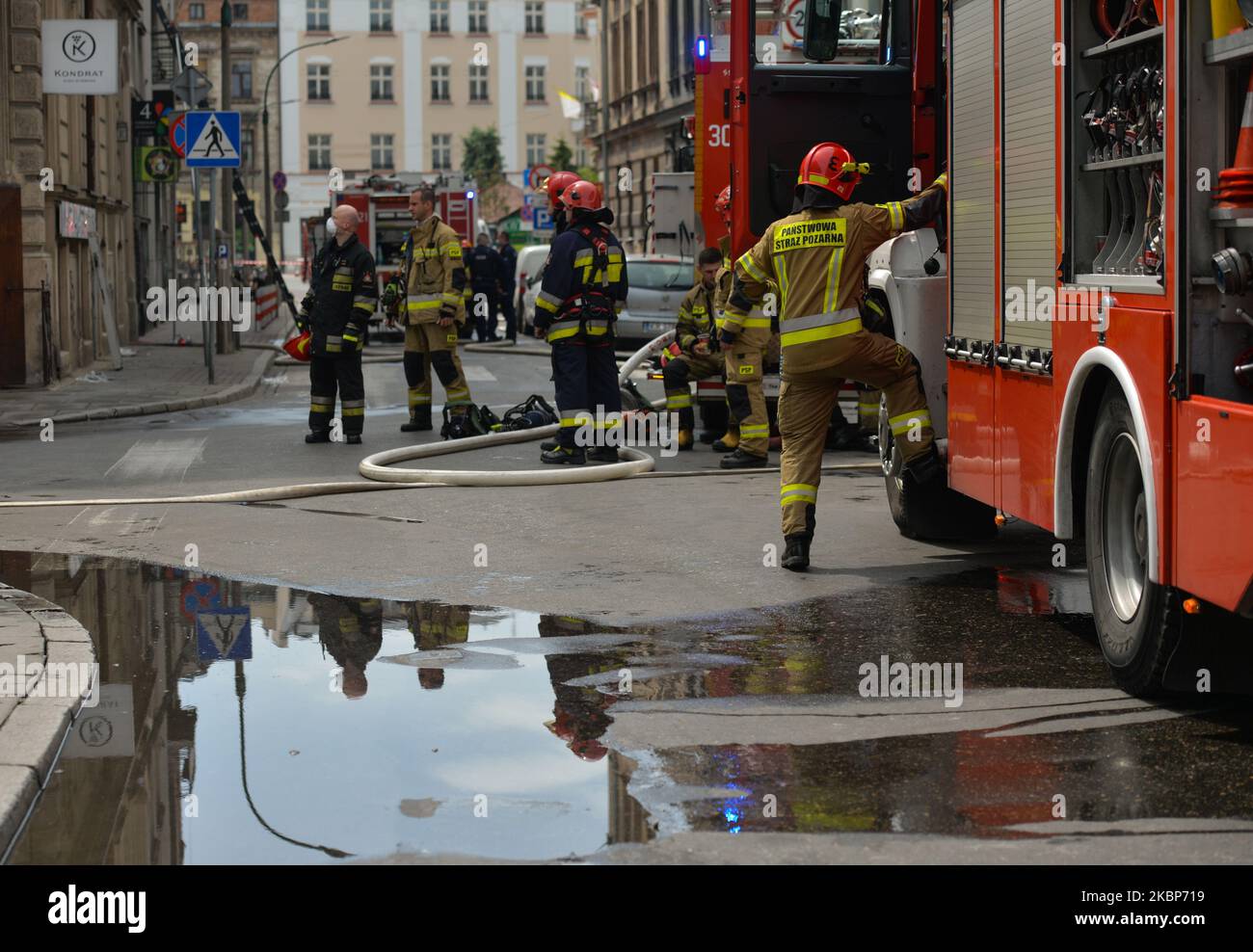 Vista di una scena antincendio con i servizi di emergenza in azione. Oltre 50 vigili del fuoco hanno partecipato a un'operazione di estinzione nel centro di Cracovia, poco prima di mezzogiorno. La soffitta di un edificio residenziale multi-famiglia ha catturato il fuoco all'intersezione di Rajska St. E Dolnych Mlynow St. A causa del fumo denso, tutti i residenti sono stati evacuati. Per fortuna, nessuno è stato ferito. Sabato 23 maggio 2020 a Cracovia, Polonia. (Foto di Artur Widak/NurPhoto) Foto Stock