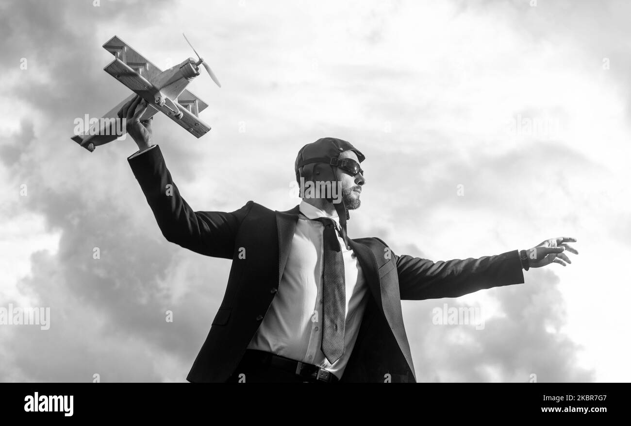 uomo d'affari in abito e cappello pilota lancia giocattolo aereo. idee Foto Stock