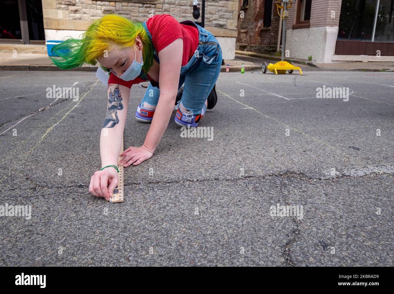 Olivia Cassinelli inizia a tracciare un profilo con il gesso come diciassette artisti e i loro assistenti iniziano a dipingere un murale Black Lives Matter su Plumb St. Sulle orme del Municipio, mercoledì 17 giugno 2020, a Cincinnati, Ohio, Stati Uniti. (Foto di Jason Whitman/NurPhoto) Foto Stock