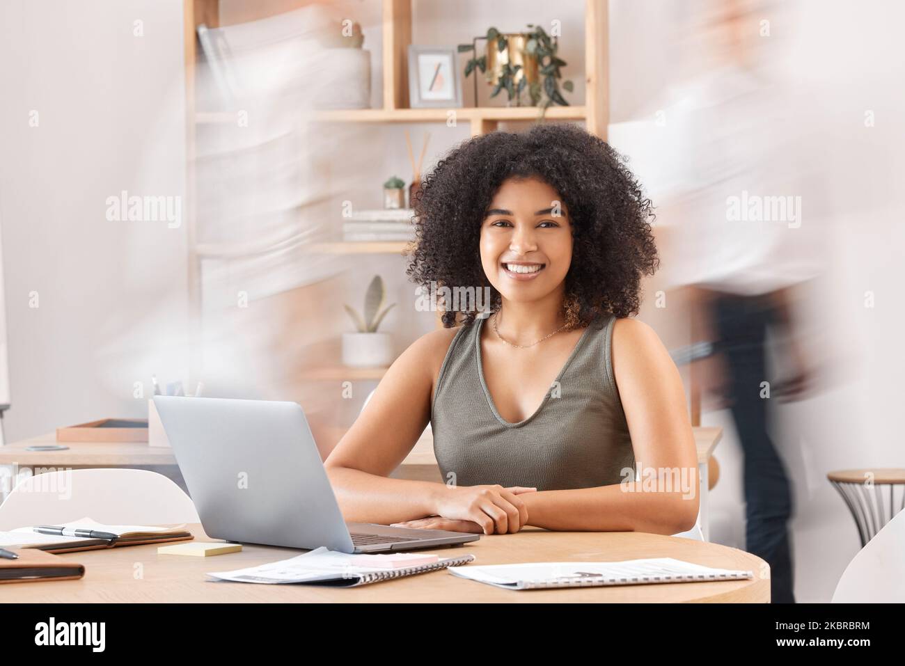 Notebook, movimento sfocato e ritratto con una donna nera che guarda calma o sicura in un luogo di lavoro occupato. Felice, focus e finanza con un dipendente femminile Foto Stock